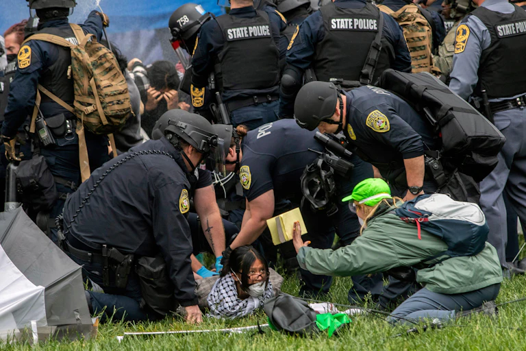American police detaining a student demonstrator.