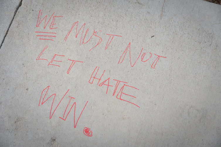 A message written on the ground in chalk following the shooting of Charlie Kirk, reading: 'we must not let hate win'.