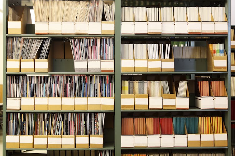 journals collected in boxes on library shelves