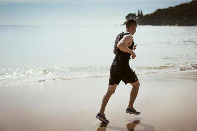 A man runs on a beach.