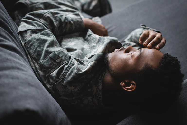 US soldier wearing fatigues lying on sofa sleep