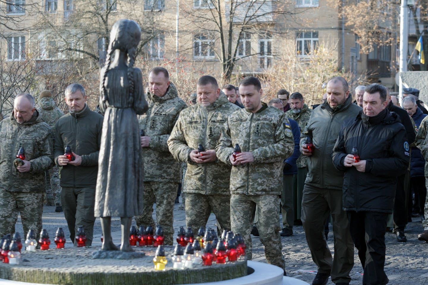 Soldiers stand before a memorial.
