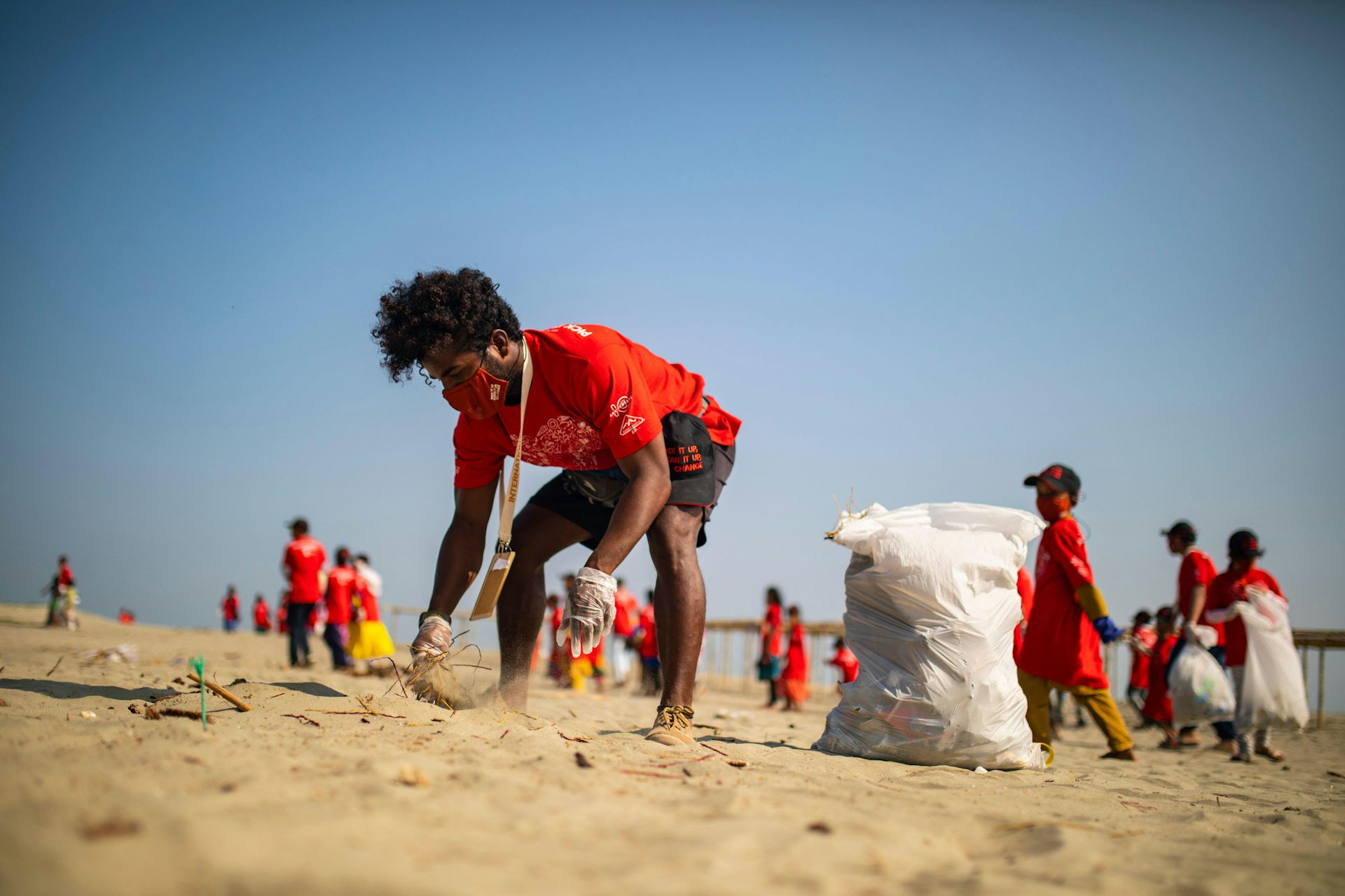People in red shirts clean beaches