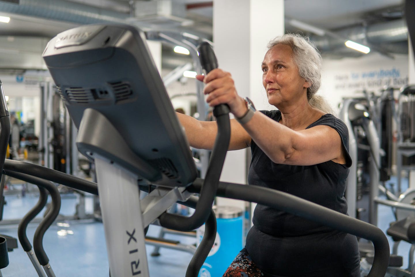 A woman with grey hair using exercise equipment.