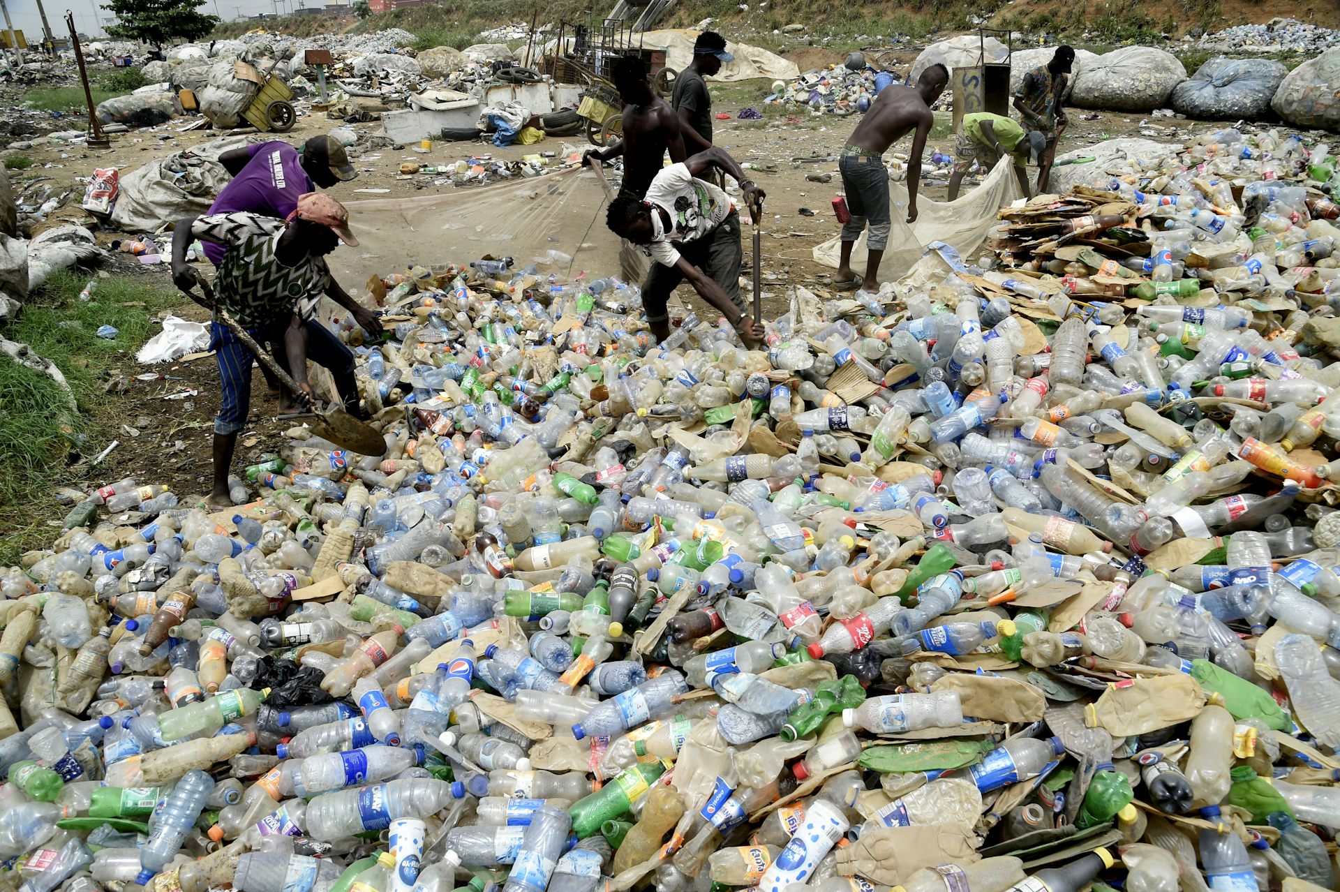 People loading plastic waste into bags 