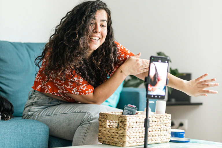 A young woman recording herself on her iPhone as she recommends a product.