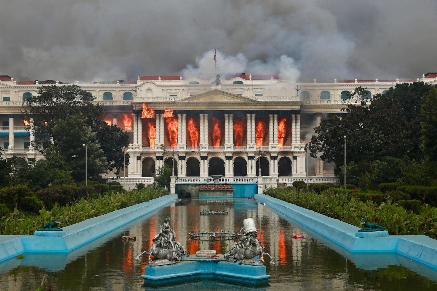 Flames are seen coming out of a large white buildins.