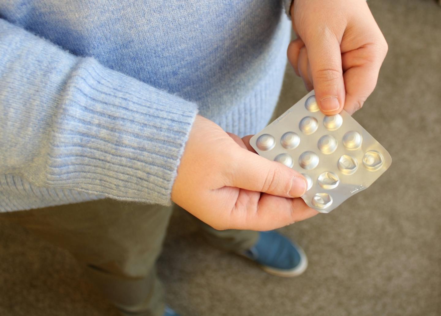 Person holding a blister pack of pills.