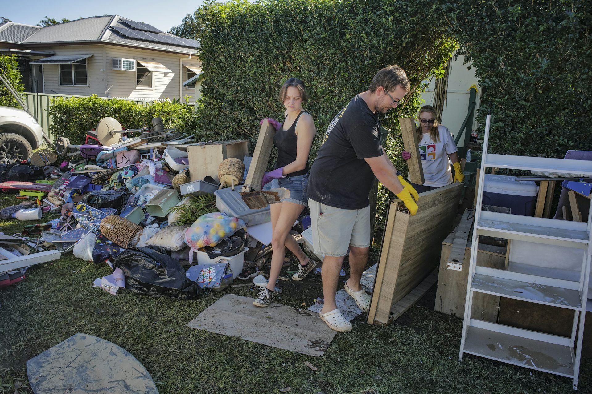 A man and his daughter carry debris to a pile