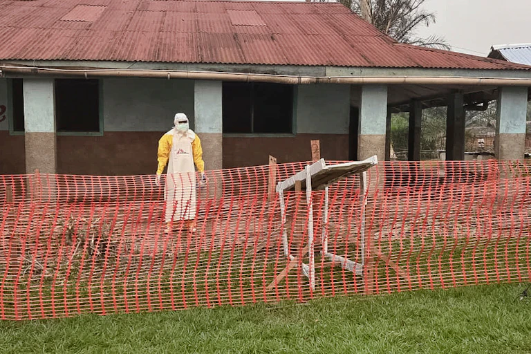 Aman wearing protective clothing stands outside an Ebola treatment center in the remote Bulape Health Zone, Kasaï province