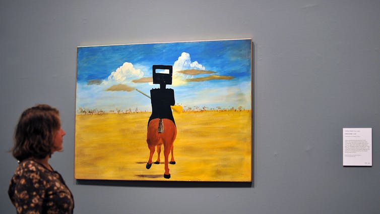 A woman looking at a painting.