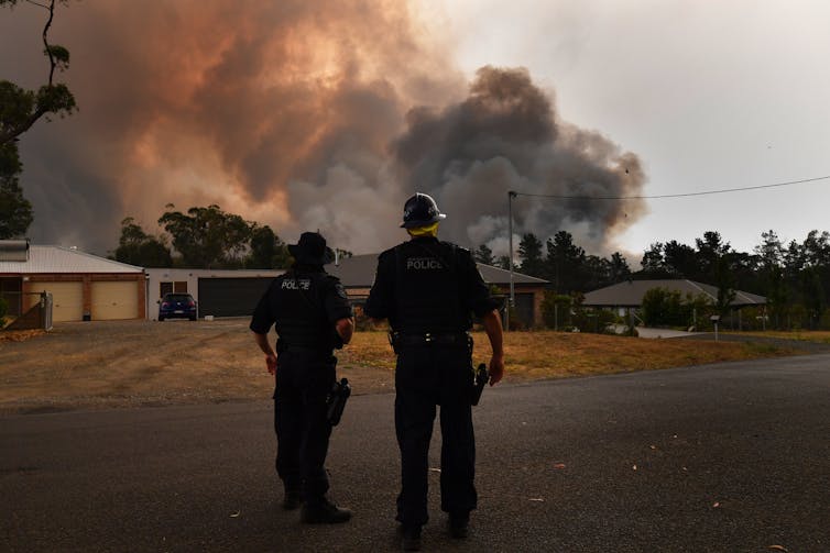 NSW Police watch as a fire threatens homes in Yandeera in the south west of Sydney in 2019
