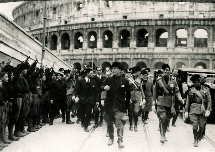 Black and white photo, in front of the colosseum.