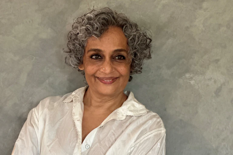 A woman in a white shirt with greying curly hair