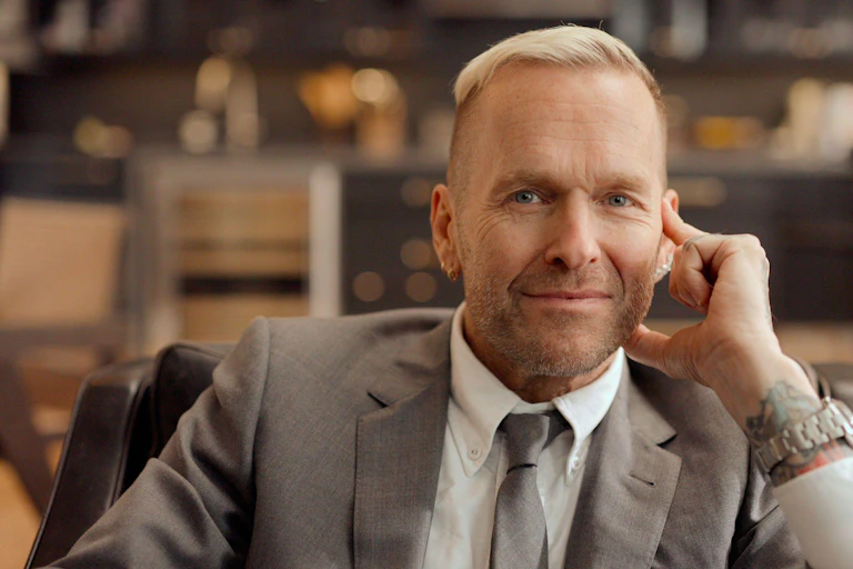 A man with thinning pale hair smiles.