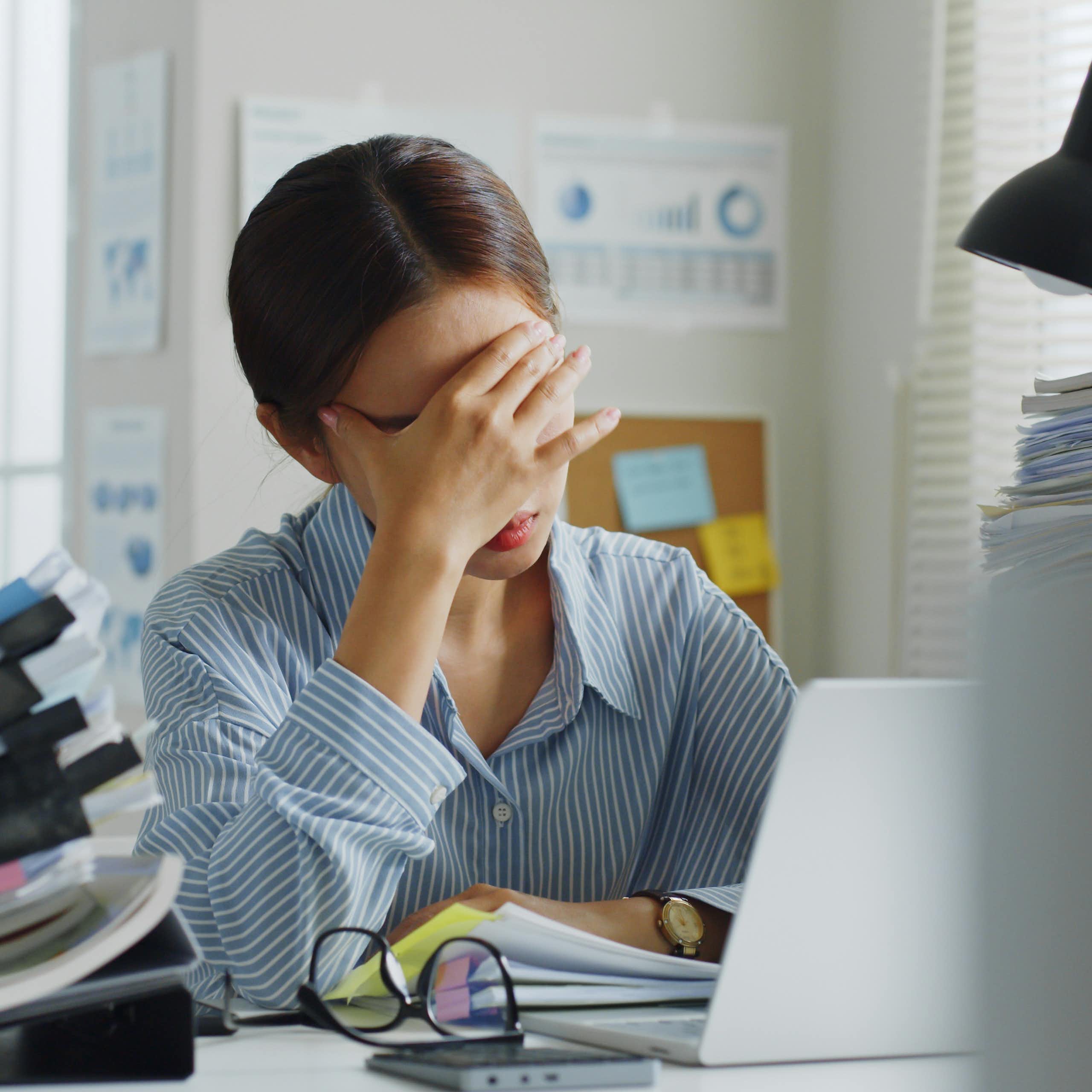 Une femme assise se prend le visage