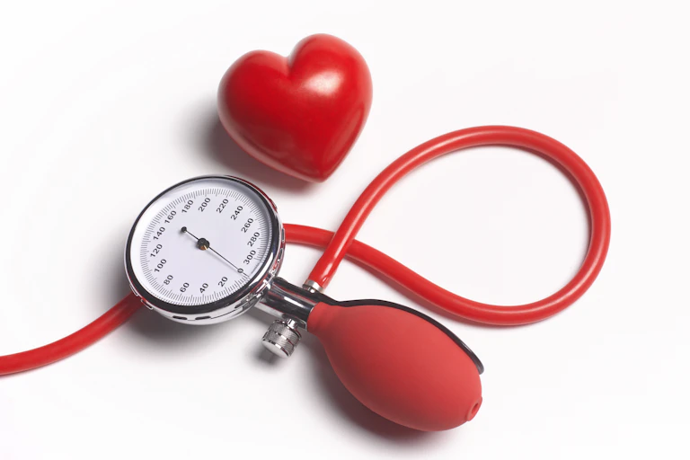 Close-up image of a bright red blood pressure gauge and red heart