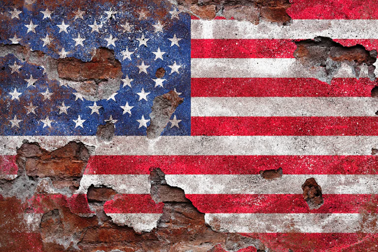 An American flag, with holes in it and looking dirty.