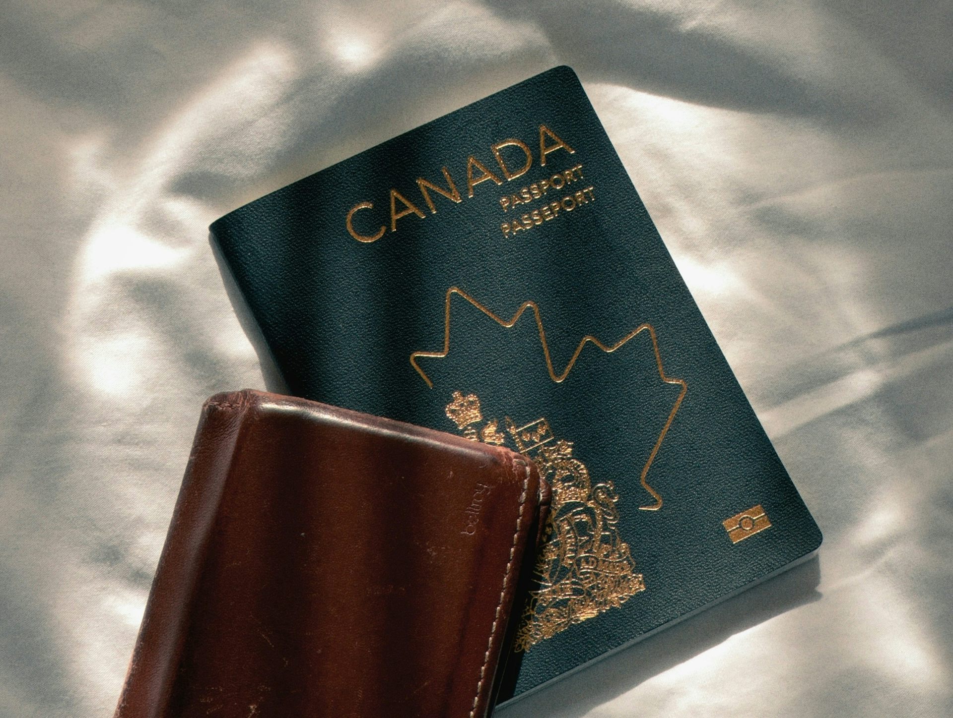 A Canadian passport and a brown wallet.