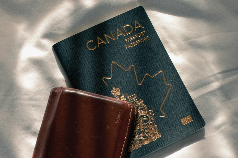 A Canadian passport and a brown wallet.