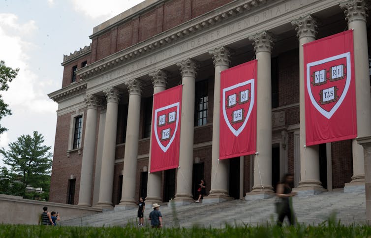 A large, columned building with red banners hanging from the front.