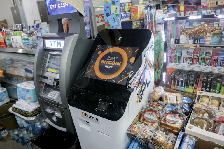 two side-by-side machines with sceens and keypads amidst shelves full off small items