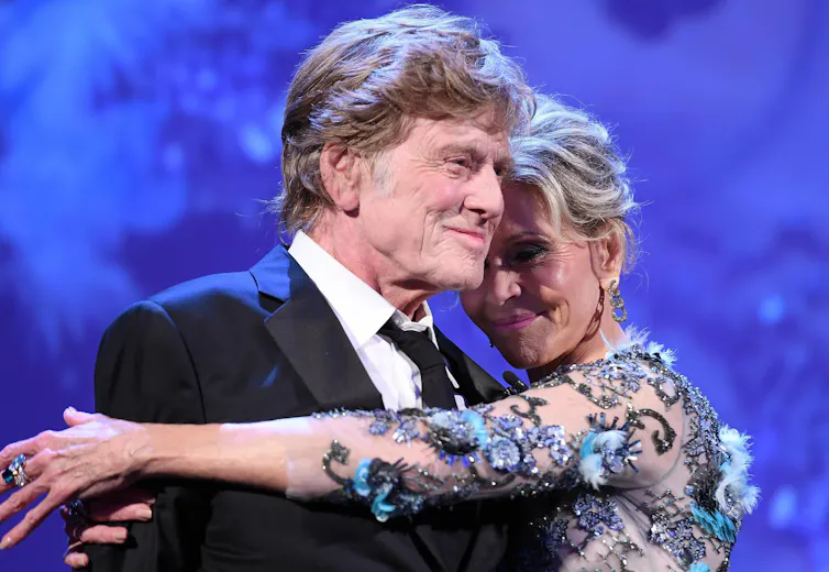 The pair embrace.
