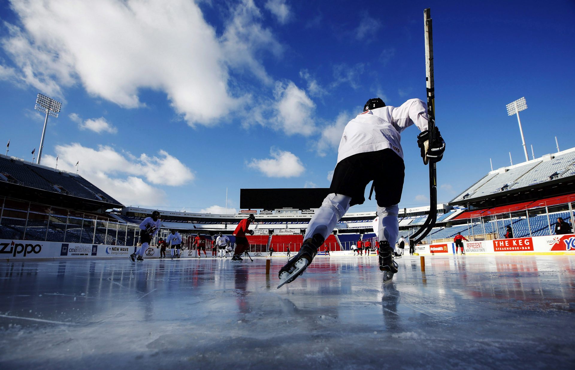 a person in hockey gear carrying a stick on the ice