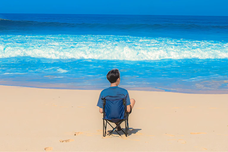 A man sitting alone on a beach
