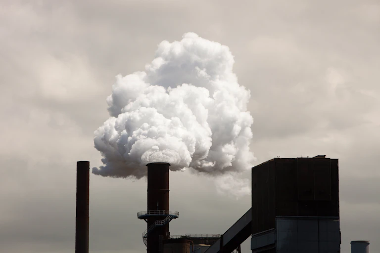 steelmaking plant smokestack putting out plume of smoke.