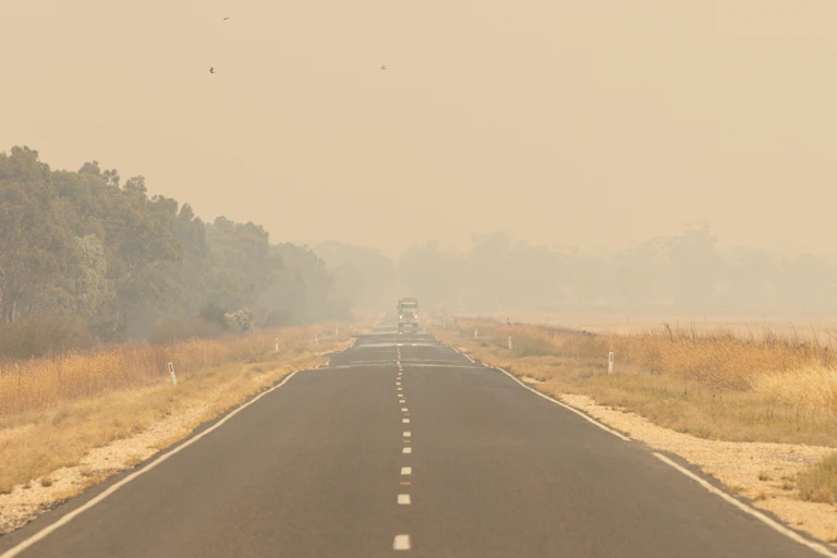 A car driving through thick bushfire smoke haze