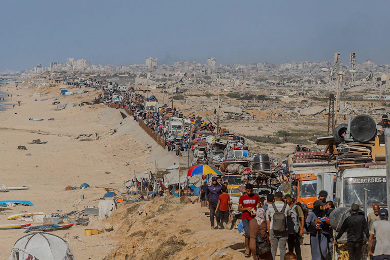 A huge column of Palestinian citizens walks out of Gaza City.