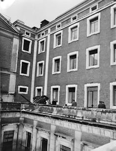 Fotografía de un edificio con un coche en un balcón.