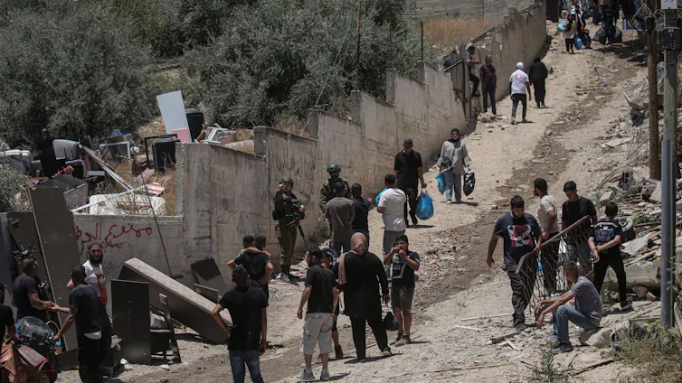 People taking their belongings out of deamaged buildings in Tulkarem, northern West Bank.