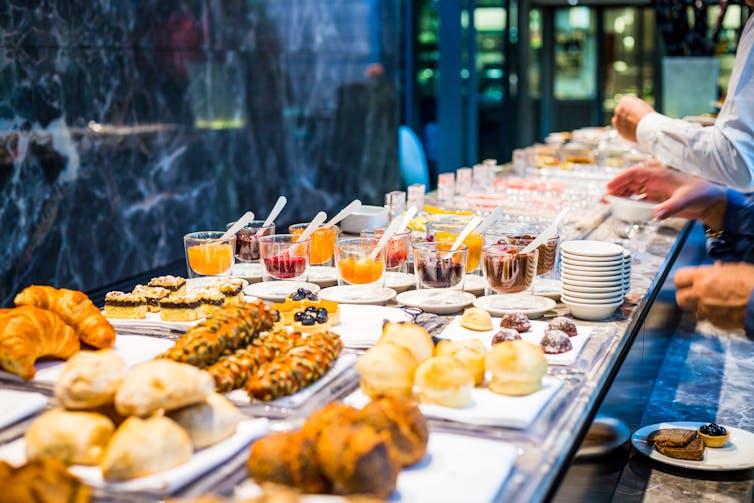 a hotel breakfast buffet with people just visible at the side