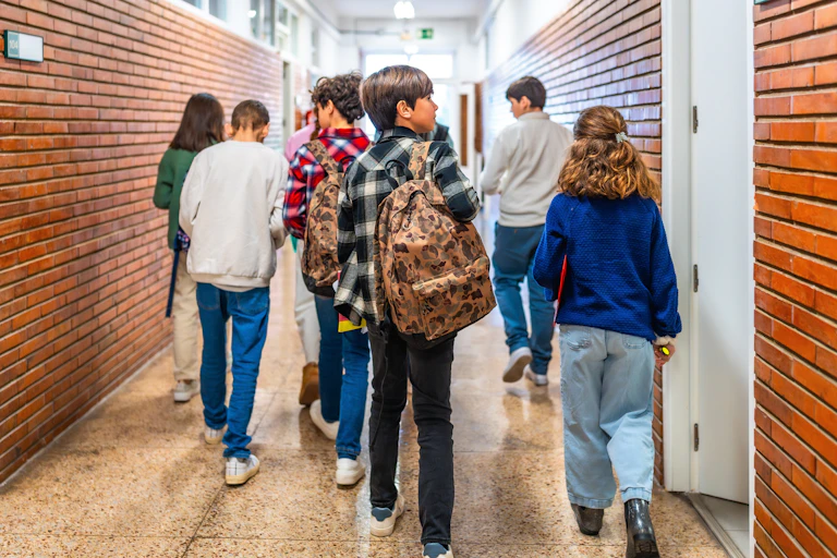 Varios niños en el pasillo de un colegio.