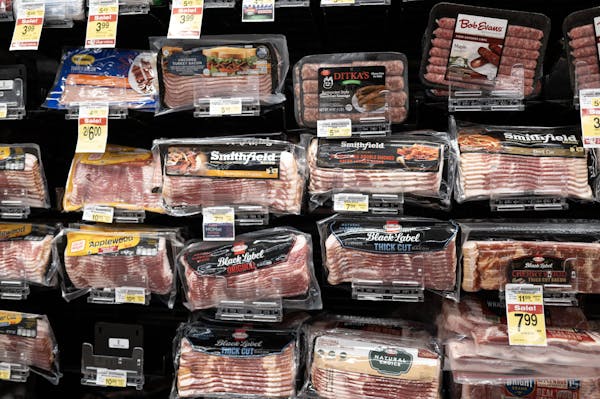 packages of bacon and other meat are on display in a grocery store