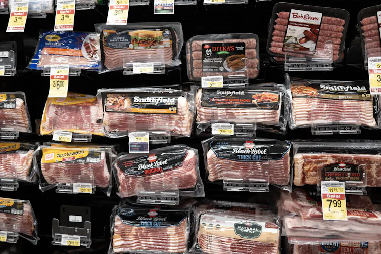packages of bacon and other meat are on display in a grocery store