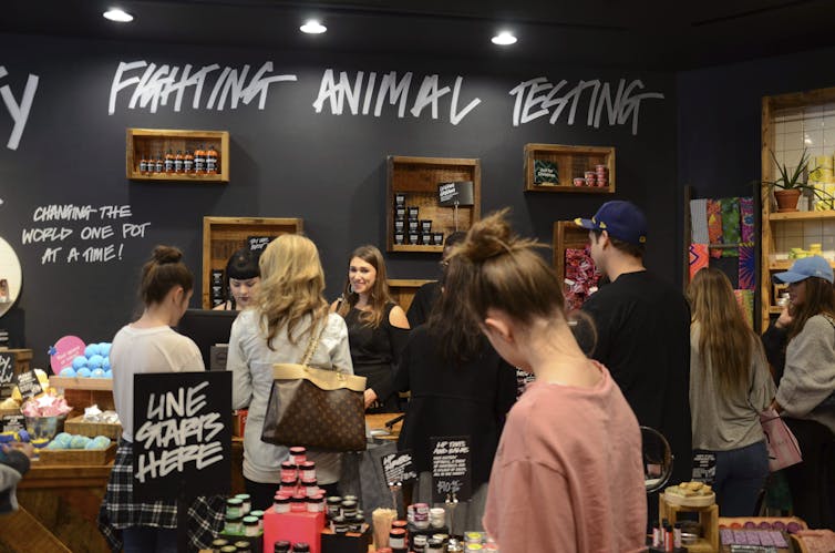 Las personas revisan los productos en la tienda de cosméticos