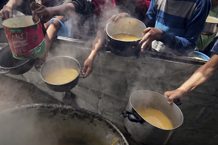 children's outreached hands carrying pots for food