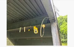 Some yellow and black equipment is attached under an overhang.