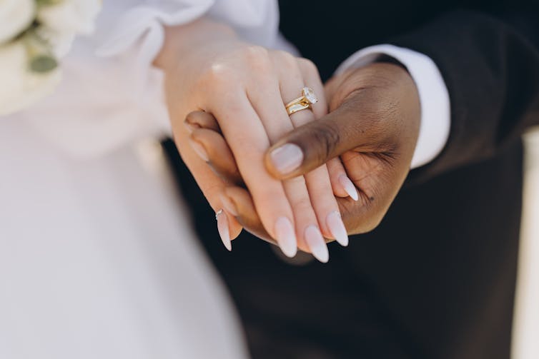 A married couple hold each other's hand.