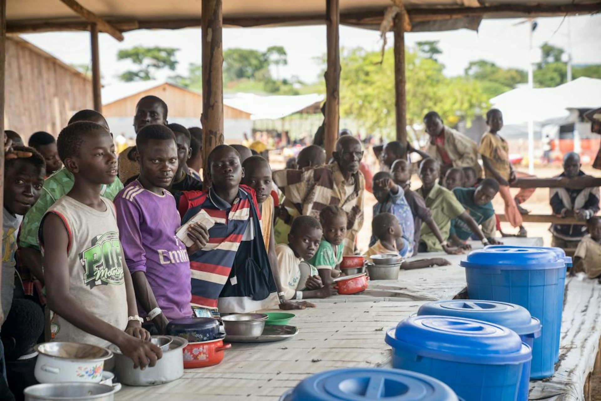 A group of people standing in front of a table with empty plates of food.