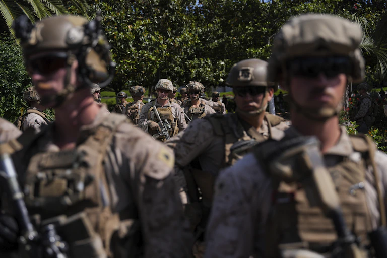 US Marines patrol a city street.
