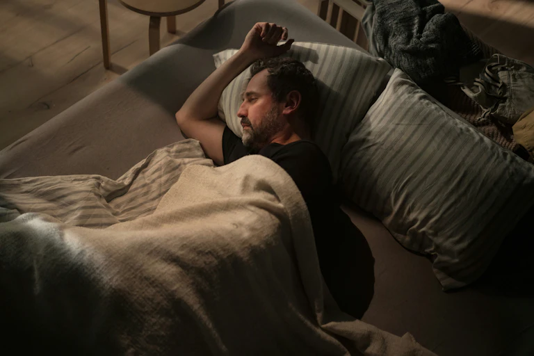 a man lying awake in a bed