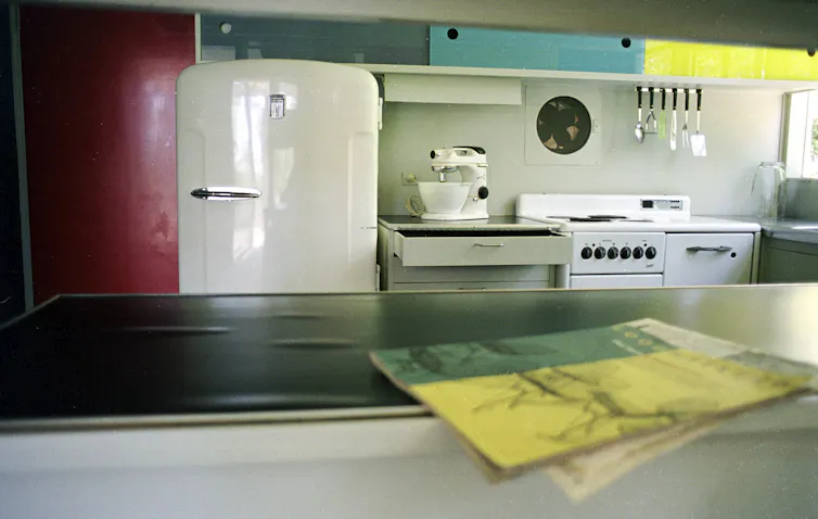 A kitchen with a fridge, mixer and stove