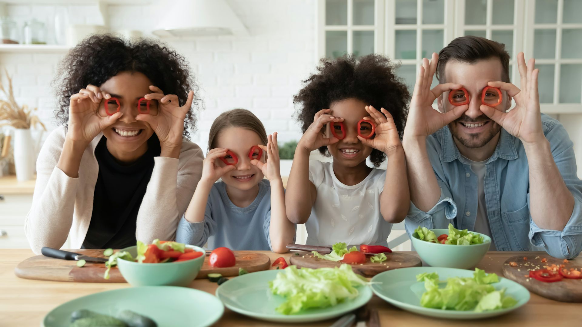 Una familia posa poniéndose anillos de pimiento a modo de gafas.
