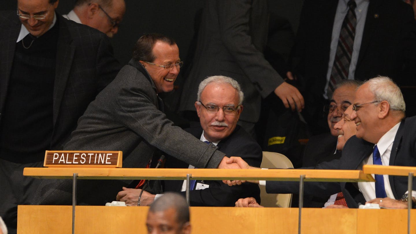 Two men shake hands.