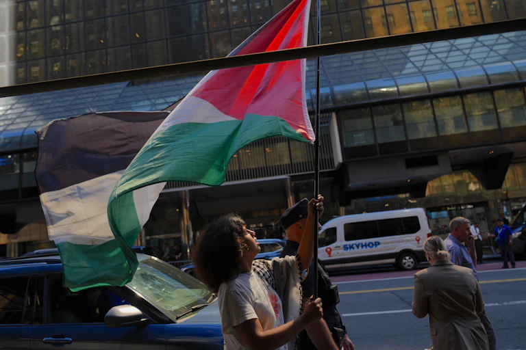 A woman holds aloft a green, white and red flag.
