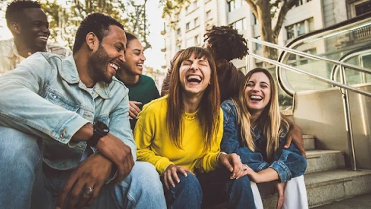 Friends sitting on some steps outdoors, having a laugh.